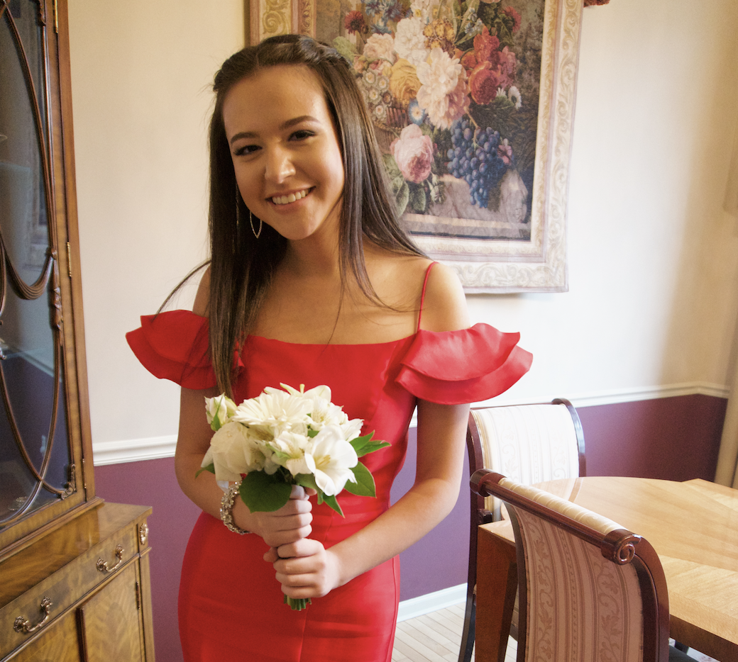 A diverse group of young adults jumping with excitement in a lush green garden during a community event.