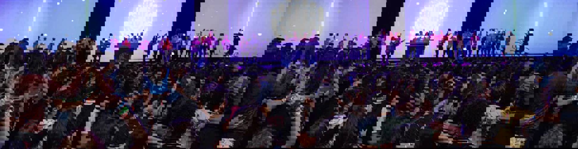 Grupo de jóvenes de diferentes orígenes sonriendo en un evento comunitario.