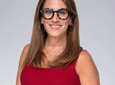 Una multitud diversa de personas celebrando en un concierto, levantando las manos y vitoreando.