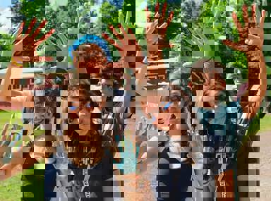 Una multitud diversa de personas celebrando en un concierto, levantando las manos y vitoreando.