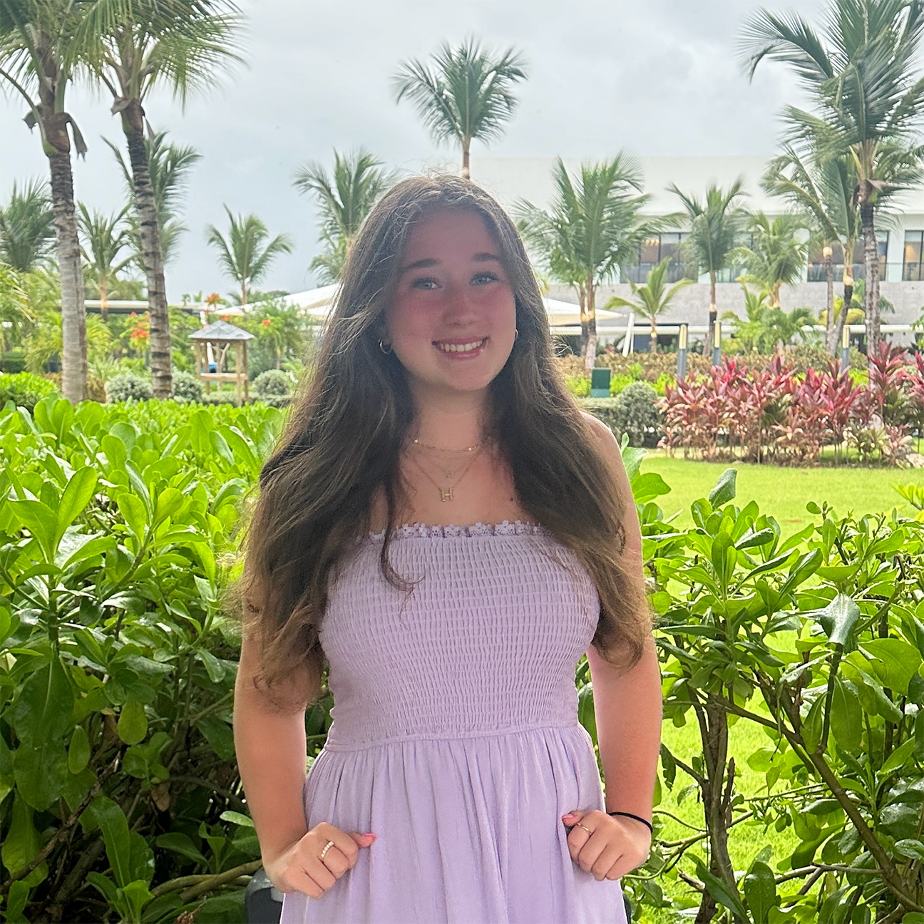 A diverse group of young adults jumping with excitement in a lush green garden during a community event.