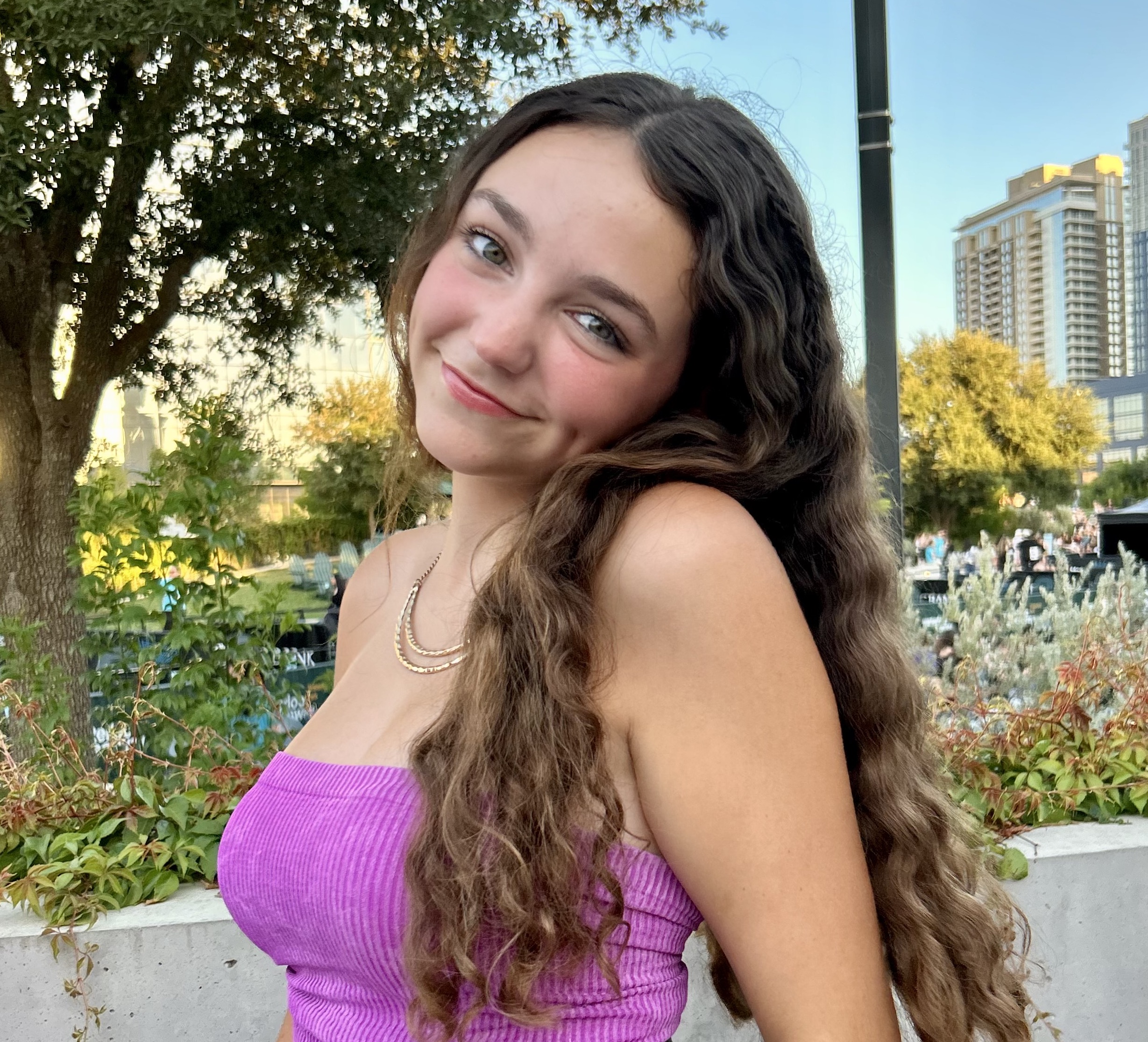 A diverse group of young adults jumping with excitement in a lush green garden during a community event.
