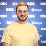 A diverse crowd of people celebrating at a concert, raising their hands and cheering.