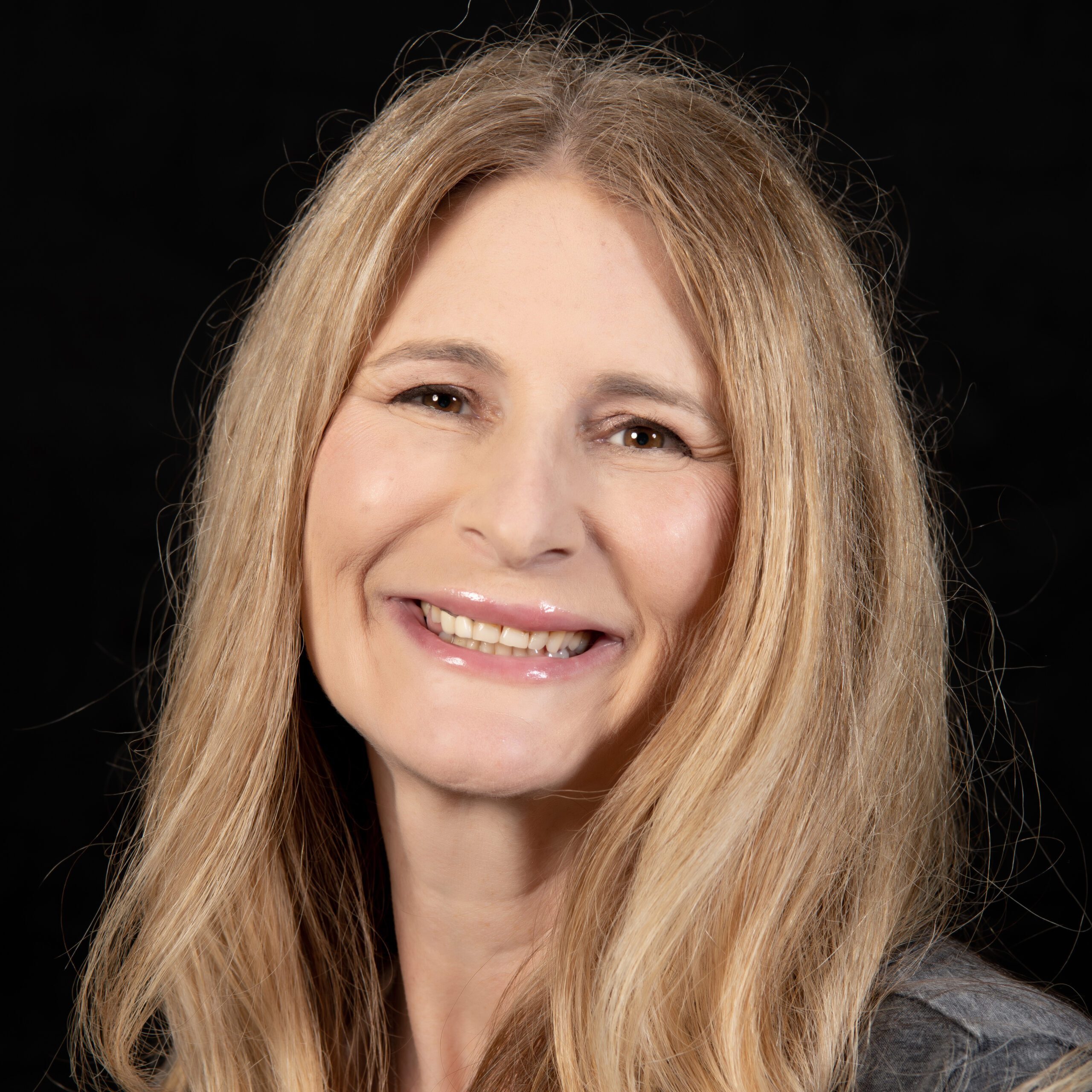 A diverse crowd of people celebrating at a concert, raising their hands and cheering.