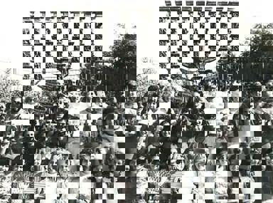 Una multitud diversa de personas celebrando en un concierto, levantando las manos y vitoreando.