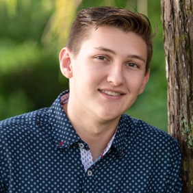 Un grupo diverso de jóvenes adultos saltando de emoción en un frondoso jardín verde durante un evento comunitario.