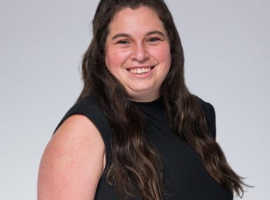 Una multitud diversa de personas celebrando en un concierto, levantando las manos y vitoreando.