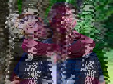 Una multitud diversa de personas celebrando en un concierto, levantando las manos y vitoreando.