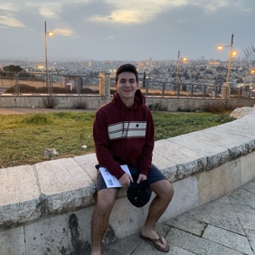 Un grupo diverso de jóvenes adultos saltando de emoción en un frondoso jardín verde durante un evento comunitario.