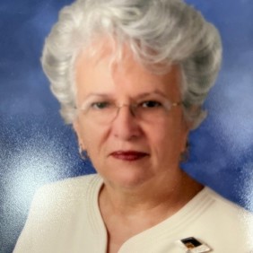 Un grupo diverso de jóvenes adultos saltando de emoción en un frondoso jardín verde durante un evento comunitario.