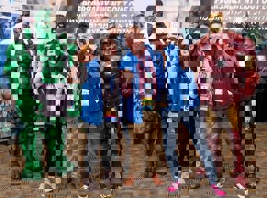 Una multitud diversa de personas celebrando en un concierto, levantando las manos y vitoreando.