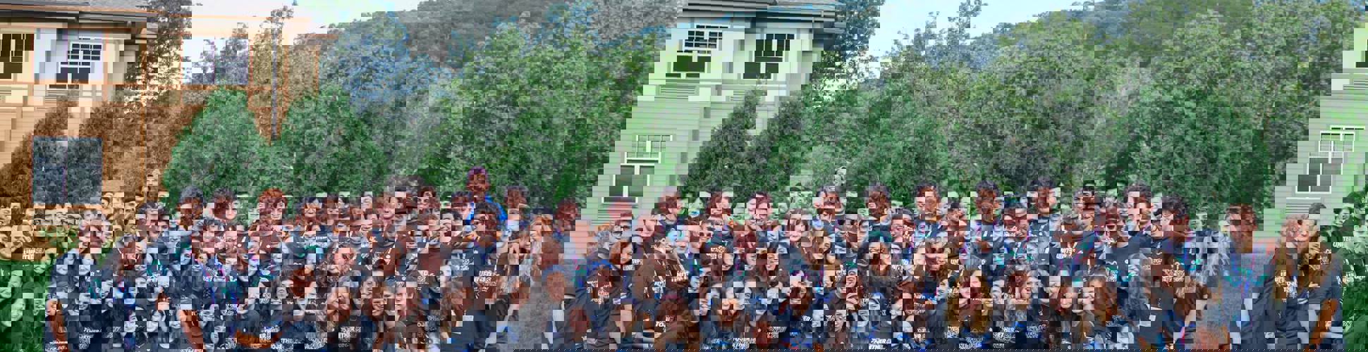 Grupo de jóvenes de diferentes orígenes sonriendo en un evento comunitario.