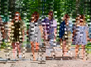 Una multitud diversa de personas celebrando en un concierto, levantando las manos y vitoreando.